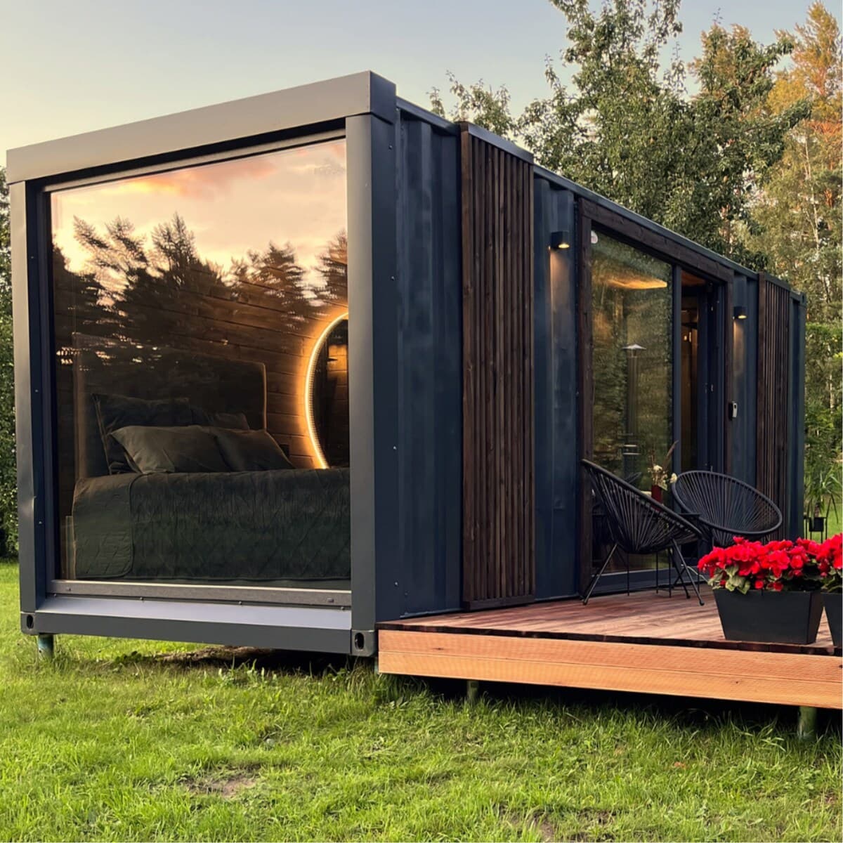 Mājiņas fasāde priežu ieskauta