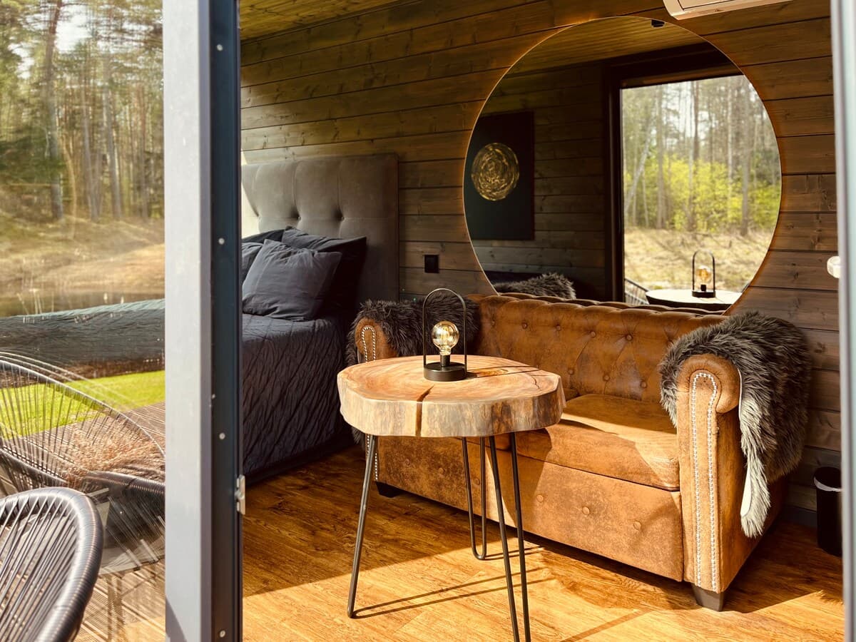 Aerial view of cabin grounds with pond and surrounding forest